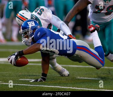 New York Giants Victor Cruz leaps over New York Jets Eric Smith as