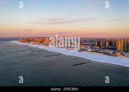 Aerial view of a snow covered Coney Island Beach during the winter at sunrise in Brooklyn, New York.