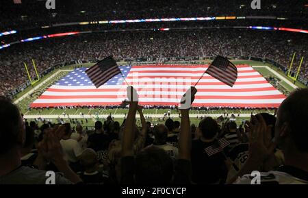 An American flag is stretched across the field at SoFi Stadium during the  national anthem before the NFL Super Bowl 56 football game between the Los  Angeles Rams and the Cincinnati Bengals