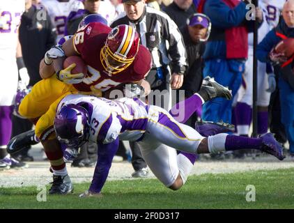 Washington Redskins Darrel Young is tackled by Minnesota Vikings' Jamarca  Sanford (33) and Chad Greenway (52) during the third quarter at FedEx Field  in Landover, Maryland on December 24, 2011. UPI/Kevin Dietsch