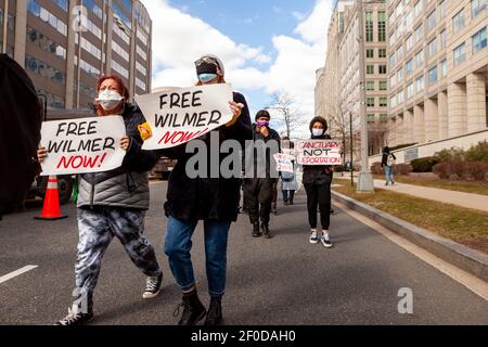 Washington, DC, USA, 6 March, 2021.  Pictured:  Protesters passing the building housing Immigration and Customs Enforcement during the Free Wilmer Now march.  Wilmer is an asylum-seeker who has been in ICE custody for 2 years, and protesters demand his release.  Credit: Allison C Bailey/Alamy Live News Stock Photo