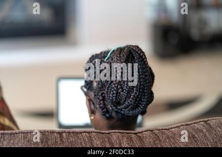 African American Nigerian woman working on her laptop from home Stock Photo