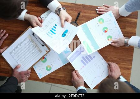 Group of business people discussing charts on paper top view Stock Photo