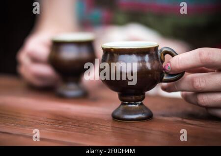 Female hands holding coffee cup over dark table Stock Photo