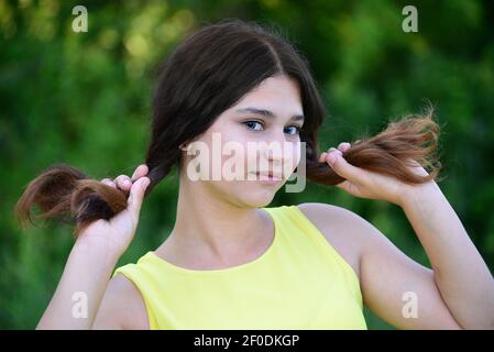 Girl holds her hair in hands Stock Photo