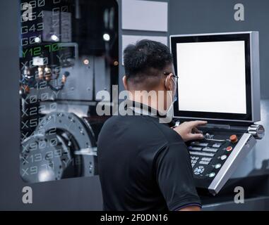 Industrial technician operating CNC machining center. CNC programming code. Metalworking manufacturing factory Stock Photo