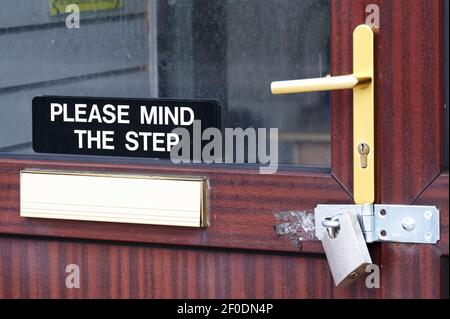 Please mind the step sign on shop entrance door Stock Photo