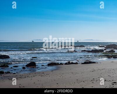 View of Santa Cruz Island in Channel Islands National Park and off shore oil rigs in Santa Brabara Channel as seen from Jelly Bowl Beach near Tar Pits Stock Photo