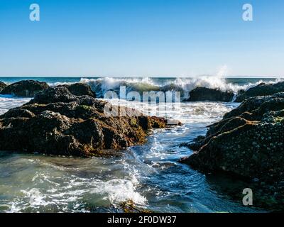 Waves and rocks in the intertidal zone at Tar Pits Beach in Carpinteria California on a sunny day. Stock Photo
