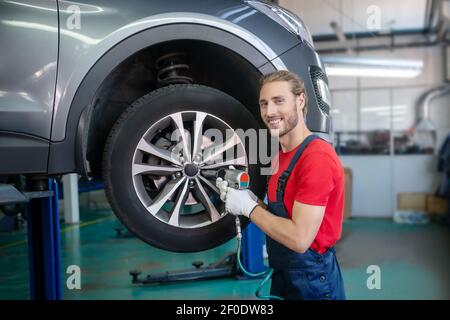Man in uniform repairing a car Stock Photo