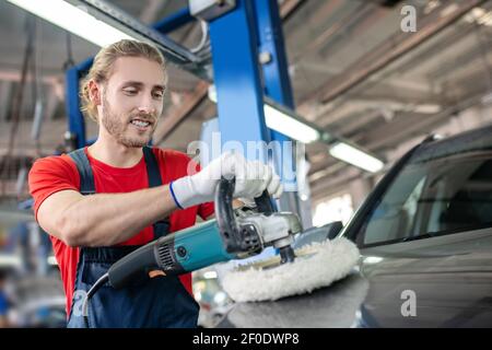 Man polishing car using polishing machine Stock Photo