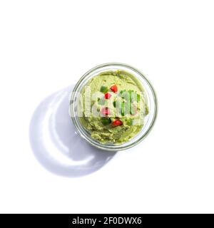 Guacamole glass bowl isolated on white background with copy space. Top view. Stock Photo