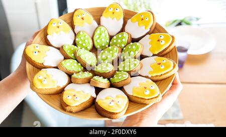 Easter gingerbread on a platter. Iceded cookies in the shape of cute chickens. Fun ideas for family baking together with children for Easter. Stock Photo