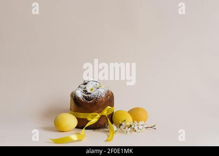 Easter composition of sweet bread cake, white flowers and yellow eggs on a light background. Orthodox Easter bread. A festive breakfast concept with s Stock Photo