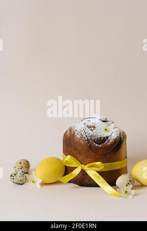 Easter composition of sweet bread cake, white flowers and yellow and quail eggs on a light background. Orthodox Easter bread. A festive breakfast conc Stock Photo