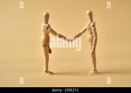 Two wooden figures shaking hands - friendship or agreement concept Stock Photo