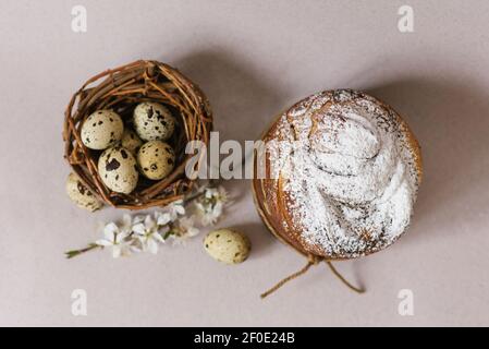 Beautiful Easter composition with quail eggs, Easter cake, the cherry blossoms are traditionally elegant. Flat lay Stock Photo