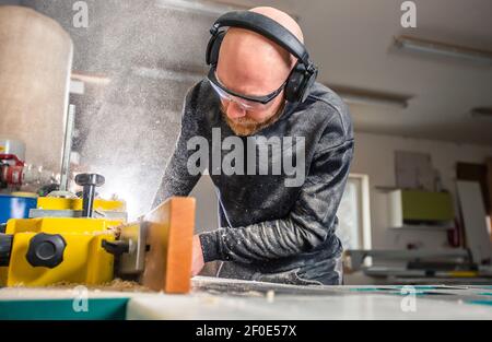 Joinery, woodworking and furniture making, professional carpenter cutting wood in the carpentry shop, industrial concept Stock Photo