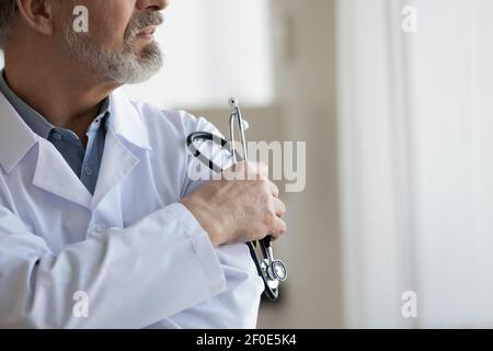 Close up of pensive mature male doctor thinking Stock Photo
