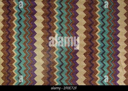 Close-up of the pattern on the knitted fabric in the form of a Christmas tree made of multi-colored stripes. Stock Photo