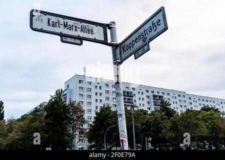 Berlin, Germany. Intersection Koppenstrasse - Karl Marx Allee, Streetname Signs and Plattenbau.