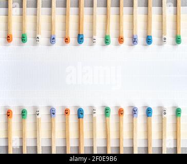 Multicolored matchsticks with faces painted on the heads on colored paper Stock Photo