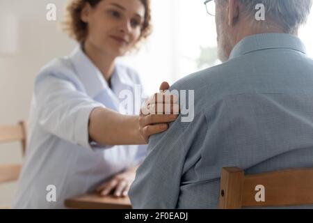 Supportive female doctor comfort elderly patient in hospital Stock Photo