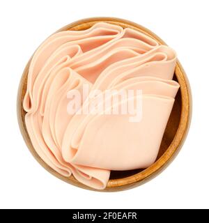 Vegetarian sausage, cold cut, in a wooden bowl. Thin slices of meatless Extrawurst, similar to Lyoner or Bologna sausage. Stock Photo