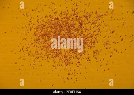 brown sugar crystal cubes on colorful yellow background Stock Photo