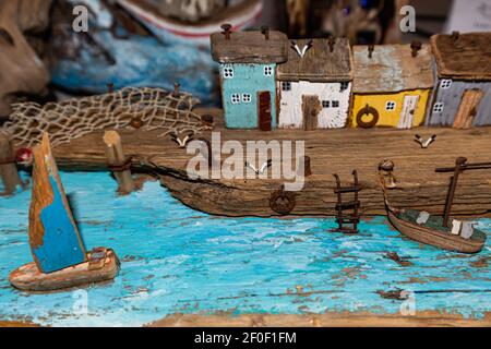 Colorful old miniature wooden houses stand on the embankment of the sea or river. Fishing nets. The boat is moored to the shore. The village of fisher Stock Photo