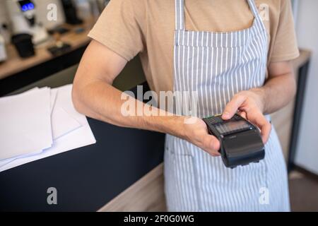 Male hands holding pos terminal pressing button Stock Photo