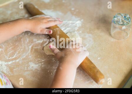 Children's hands holding rolling pin Stock Photo