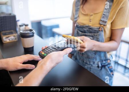 Female hands holding smartphone near poster Stock Photo