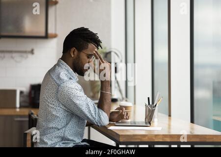 Side view thoughtful African American businessman working on research project Stock Photo