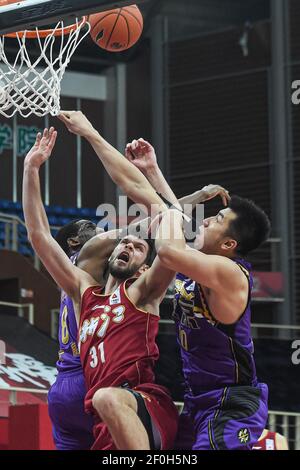 (210307) -- ZHUJI, March 7, 2021 (Xinhua) -- Nicholas Rakocevic (C) of Zhejiang Golden Bulls is blocked by Wang Shaojie (R) and Ekpe Udoh of Beijing Royal Fighters during the 42nd round match between Zhejiang Golden Bulls and Beijing Royal Fighters at the 2020-2021 season of the Chinese Basketball Association (CBA) league in Zhuji, east China's Zhejiang Province, March 7, 2021. (Xinhua/Jiang Han) Stock Photo