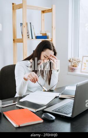 Remote Accounting Finance Jobs. Online Accounting Solution. Candid portrait of female accountant working with laptop, calculator and documents at home Stock Photo