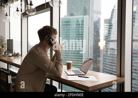Rear view confident businessman talking on phone, looking out window Stock Photo