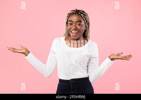 Happy positive emotional young black woman spreading palms Stock Photo