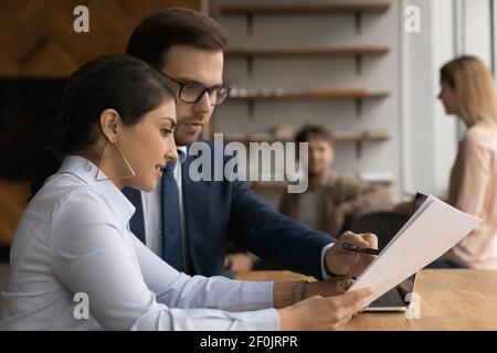 Close up diverse colleagues working on project together, checking documents Stock Photo