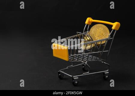 bit coin in yellow trolley on black background, electronic virtual money for web banking and international network payment, Currency Technology Busine Stock Photo