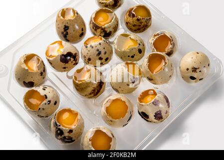 open quail eggs with exposed yolk and albumen, isolated on white background Stock Photo