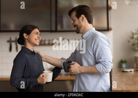 Diverse colleagues drinking coffee, chatting during break, enjoying pleasant conversation Stock Photo
