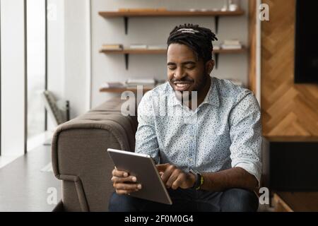 Close up smiling African American man using tablet, browsing apps Stock Photo