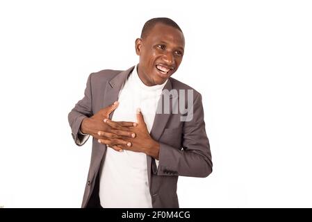 young man standing in suit on white background looking in profile laughing. Stock Photo