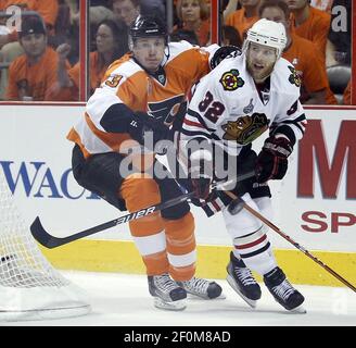 Boston Bruins left wing Marco Sturm (16) chases down a loose puck with  Philadelphia Flyers defenseman Oskars Bartulis (3) putting pressure on him  in the third period of the 2010 Bridgestone NHL