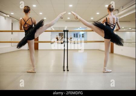 Elegant teen ballerinas, stretching at the barre Stock Photo