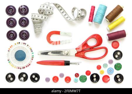 Set of sewing accessories: spools of thread, needle, a pair of button scissors and a tape measure Stock Photo
