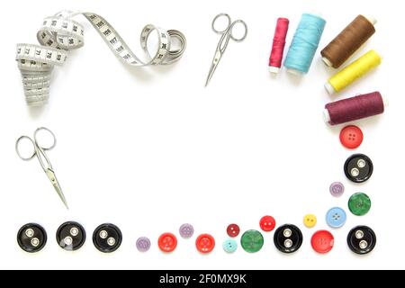 composition with colorful sewing tools and accessories cut-out and isolated in white frame with scissors, buttons and tape measure Stock Photo