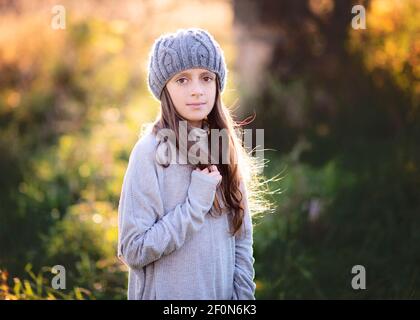 Beautiful young tween girl in sweater and hat outdoors in the fall. Stock Photo