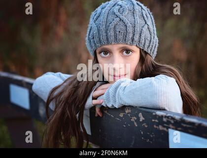 Beautiful young tween girl in sweater and hat outdoors in Fall. Stock Photo